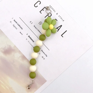 Detail of frosted acrylic flower charm with green beads and silver lobster clasp