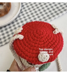 Close-up of handmade mushroom crochet crossbody bag with red and white knit patterns