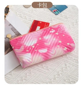Macro shot of a quilted gradient card holder with butterfly patterns and a gold zipper