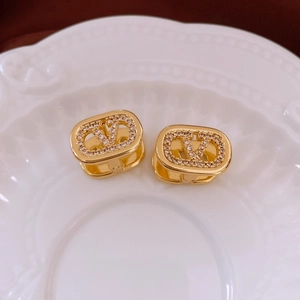 Macro detail of gold plated oval earrings featuring crystal pavé V-shaped center motif