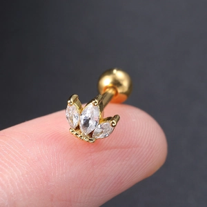 Golden lotus stud earring with marquise cubic zirconia held on a fingertip