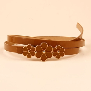 Brown skinny leather belt with floral buckle on a beige background for dresses