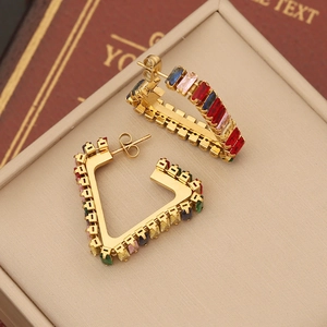 Macro shot of gold C-shape earrings with multi-colored rectangular zircon stones
