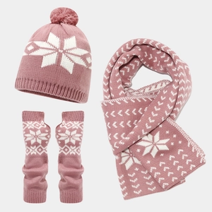 Close-up of pink knitted winter set featuring white snowflake pattern and soft textures