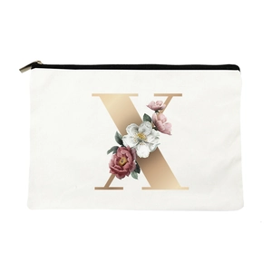 Detail of canvas makeup bag with floral letter X design and black zipper closure
