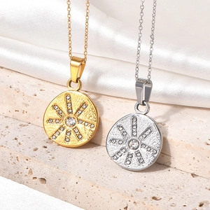 Detailed macro view of gold and silver hexagram zircon necklaces on beige stone and white silk