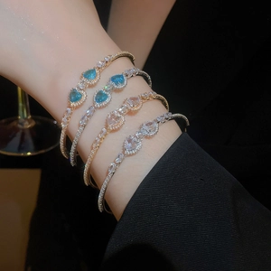 Detail of luxury heart and teardrop zircon bracelets in blue and white on wrist