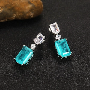 Elegant Paraiba sapphire drop earrings with geometric zircons on a dark stone background