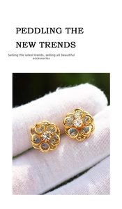 Detailed macro view of light blue crystal flower earrings with golden petal frame set
