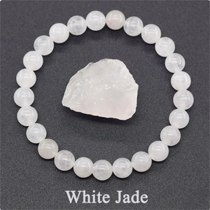 Macro view of white jade beaded elastic bracelet shown with raw natural stone