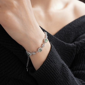 Détail du bracelet en argent avec pierre verte et zircons sur le poignet d'un modèle