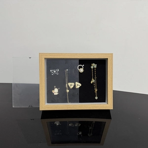 Detail of wooden jewelry display case with black velvet lining and transparent dust cover