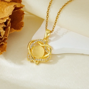 Detail of golden heart pendant with yellow gemstone and pavé zircons on silk fabric