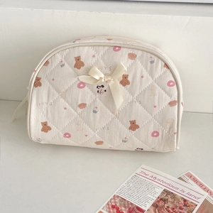 Detail of quilted cotton cosmetic bag with cute bear prints and a silk bow decoration