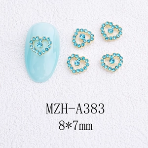 Détail de bijoux d'ongles cœur évidé doré avec strass bleu clair, taille 8x7mm