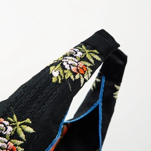 Serre-tête ethnique avec broderies florales, nœud central et bords rayés bleus