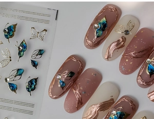Macro shot of 5D embossed butterfly nail stickers with blue wings and gold glitter rhinestones