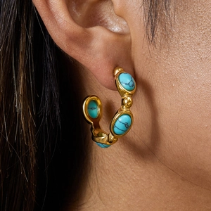 Golden titanium steel hoop earrings with turquoise stones and pearls on model