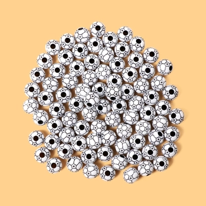 Macro view of black and white acrylic soccer beads for DIY jewelry making and crafts