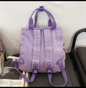 Back view of purple canvas backpack with wide shoulder straps and adjustable buckles