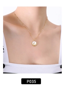 Dettaglio collana in titanio placcato oro 18K con ciondolo tondo in madreperla su modella