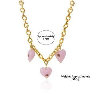 Detailed macro view of three pink Murano glass heart pendants on gold plated chunky chain