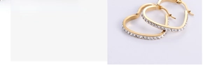 Detail of gold heart hoop earrings with sparkling white rhinestones on polished steel