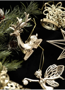Macro di renne e campane dorate su velluto nero con rami di pino e decorazioni festive