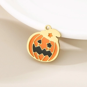 Detail of gold pumpkin charm with orange enamel and star accent for DIY jewelry
