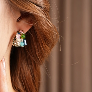 Close-up of vintage geometric cluster earrings with colorful crystals on a model