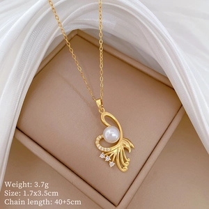 Detailed view of a gold swan pendant necklace with small zircon stones and a pearl inlay