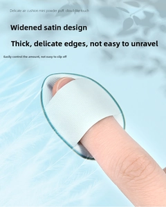 Macro detail of mini fingertip puff with wide satin ribbon for precise concealer blending