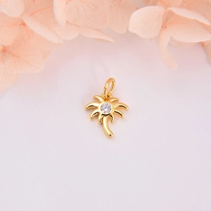 Detailed close-up of a gold palm tree pendant with a sparkling round zircon stone