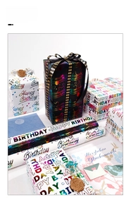 Detail of Happy Birthday wrapping paper with colorful foil letters and festive ribbons