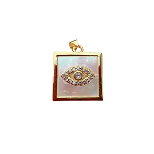 Square gold pendant with mother of pearl inlay and crystal evil eye motif on white background