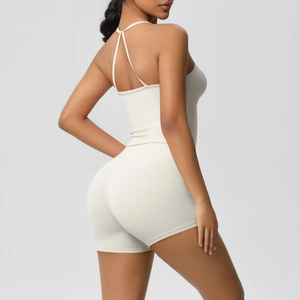 Detail view of cream backless yoga jumpsuit with thin straps and athletic fabric