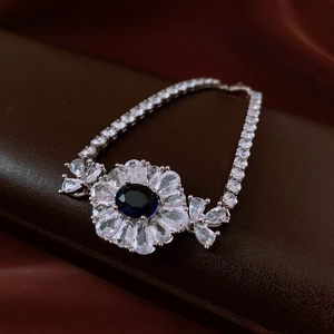 Vue macro du bracelet fleur saphir bleu avec pierres de zircon et détails trèfle