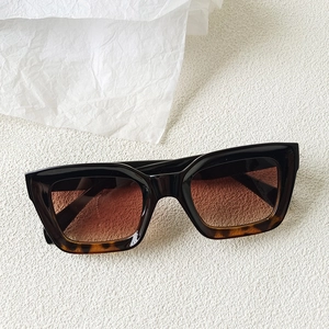 Detail of square gradient black to tortoiseshell sunglasses with brown lenses