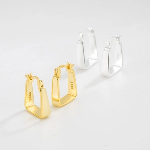 Macro detail of geometric S925 sterling silver earrings showing the hallmark and polished finish