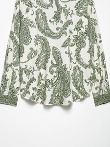 Detail of long sleeve paisley print blouse showing buttoned cuffs and curved hemline