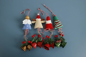 Detailed overhead view of four handmade crochet Christmas bells with festive decorations