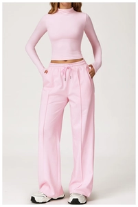 Detail of pink high-waist yoga set featuring drawstring wide-leg pants and ribbed fabric