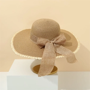 Detail of elegant straw sun hat with woven lace edges and stylish bow decoration