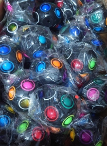 Bulk pack of 12-hole rainbow puzzle balls in black finish with colorful push buttons