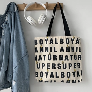 Detail of canvas tote bag featuring cute yellow rabbit illustration and typography print