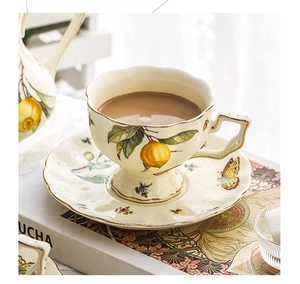 Close-up of ceramic tea cup set with lemon and butterfly patterns and gold trim