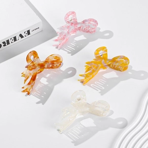 Set of four large acetate bow hair claws in marble and amber textures for women