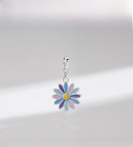 Macro shot of colorful enamel sunflower pendant with polished silver finish and spring clasp