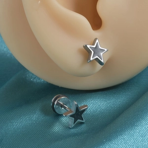 Gros plan de boucles d'oreilles étoiles en acier inoxydable et émail noir sur soie bleue