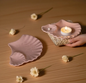 Detailed view of pink shell-shaped ceramic tray for jewelry storage and candles